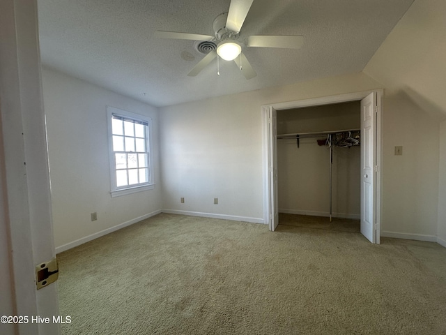 unfurnished bedroom featuring a textured ceiling, carpet floors, a closet, and baseboards