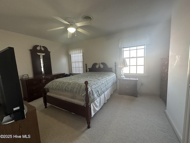 bedroom with ceiling fan, visible vents, and light colored carpet