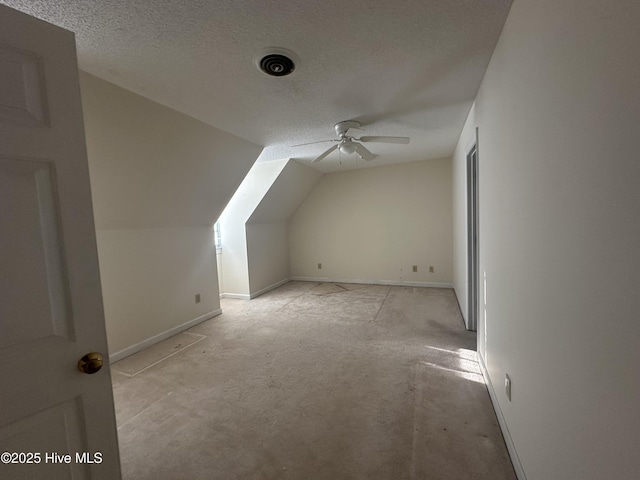 bonus room with vaulted ceiling, a textured ceiling, baseboards, and ceiling fan