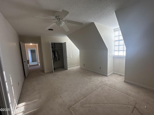 bonus room featuring ceiling fan, a textured ceiling, and baseboards