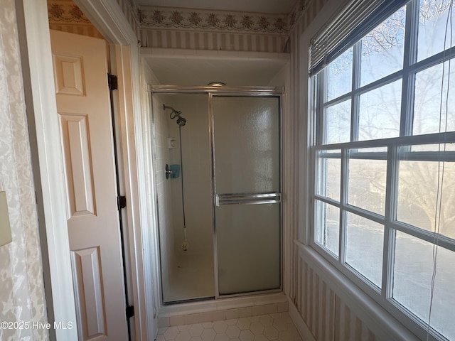 bathroom with a stall shower, tile patterned flooring, and a wealth of natural light