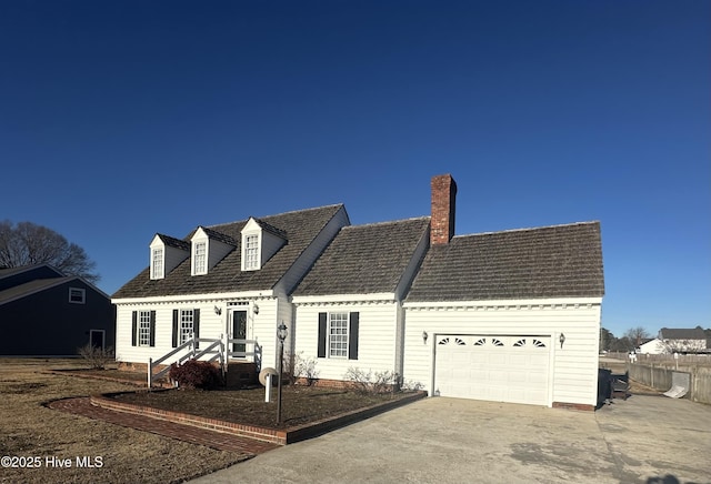 cape cod home with a garage, a chimney, and concrete driveway