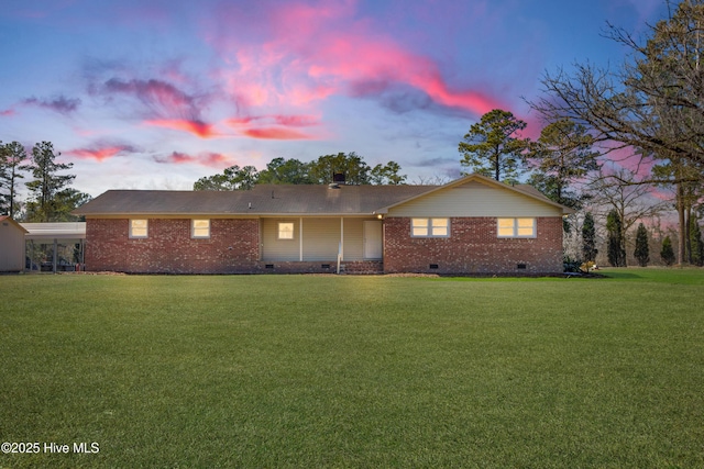 ranch-style house featuring a carport, crawl space, brick siding, and a front lawn