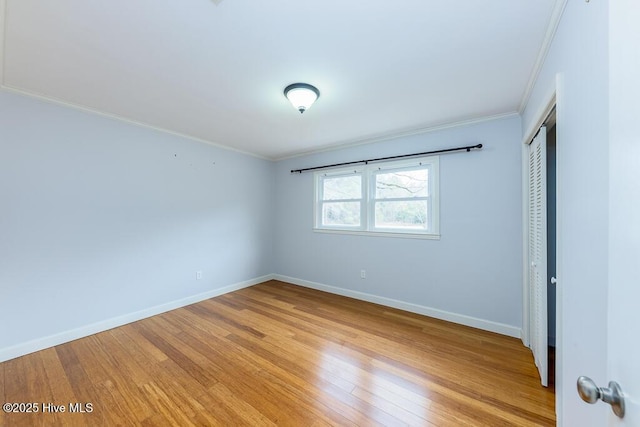 empty room with ornamental molding and light hardwood / wood-style flooring