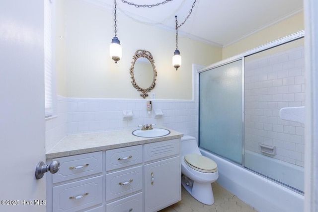 full bathroom with toilet, vanity, tile patterned floors, tile walls, and bath / shower combo with glass door