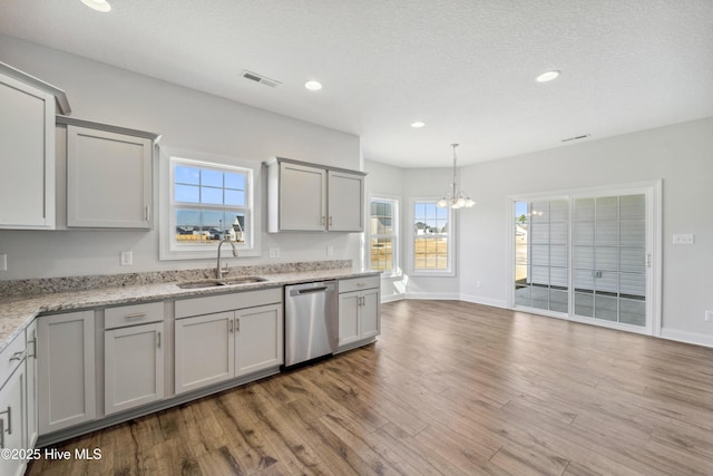 kitchen featuring stainless steel dishwasher, gray cabinets, sink, and light hardwood / wood-style flooring