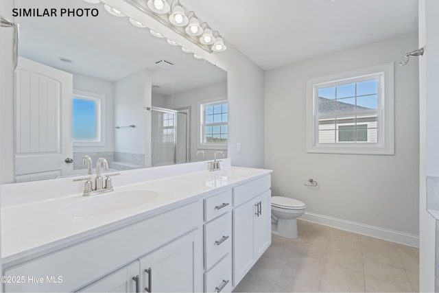 bathroom featuring vanity, tile patterned flooring, toilet, and walk in shower