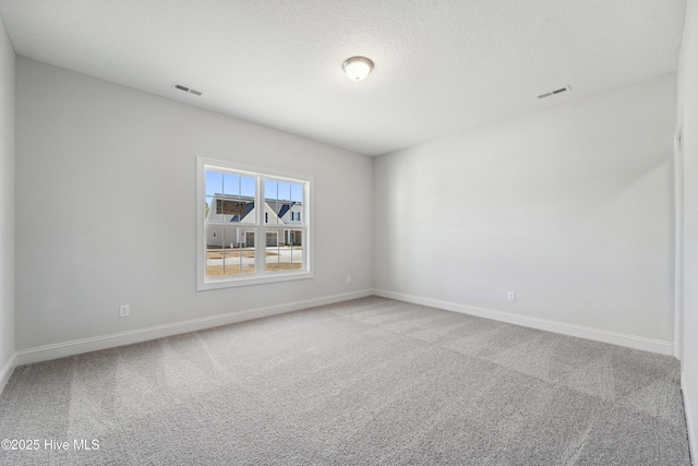 carpeted empty room with a textured ceiling