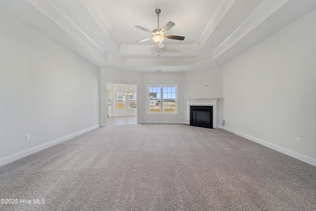 unfurnished living room with ceiling fan, light colored carpet, ornamental molding, and a raised ceiling