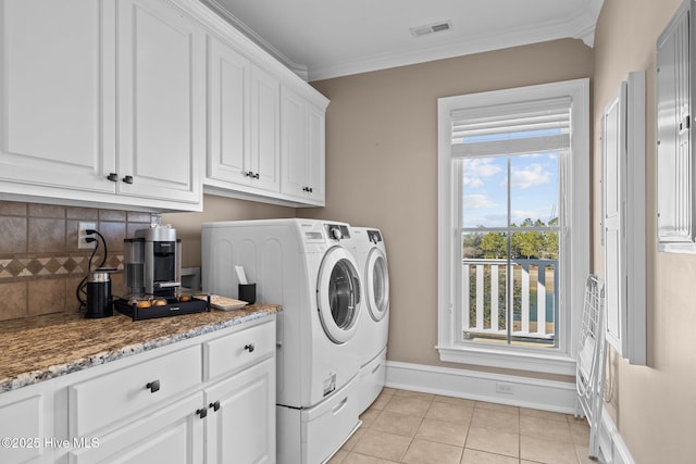 washroom with crown molding, washer and dryer, and light tile patterned floors