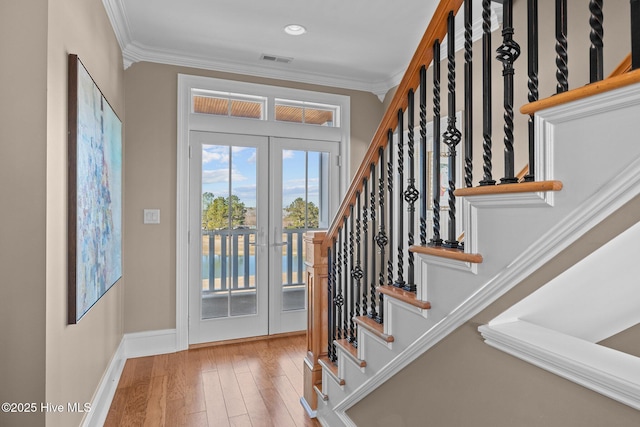 interior space featuring crown molding, light hardwood / wood-style floors, and french doors