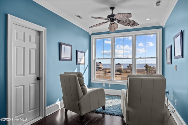 sitting room with dark wood-type flooring, ceiling fan, and ornamental molding