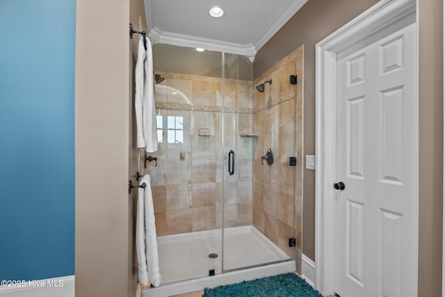 bathroom with crown molding and a shower with shower door