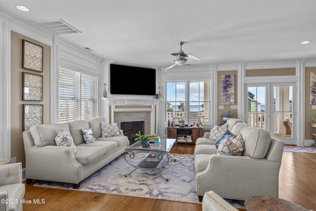 living room with hardwood / wood-style flooring, ceiling fan, and ornamental molding