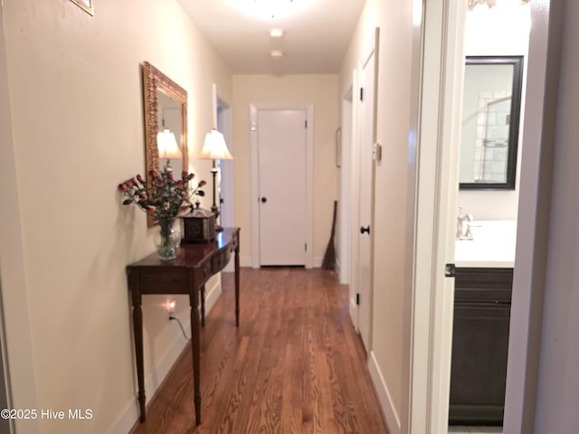 hallway featuring wood-type flooring and sink