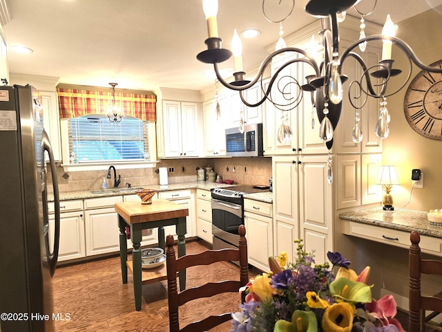 kitchen featuring light stone countertops, appliances with stainless steel finishes, dark wood-type flooring, white cabinetry, and sink