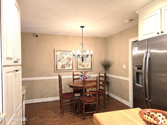 dining room with dark hardwood / wood-style floors and a notable chandelier