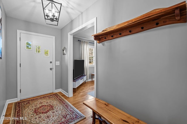 entryway with light wood-type flooring and a chandelier