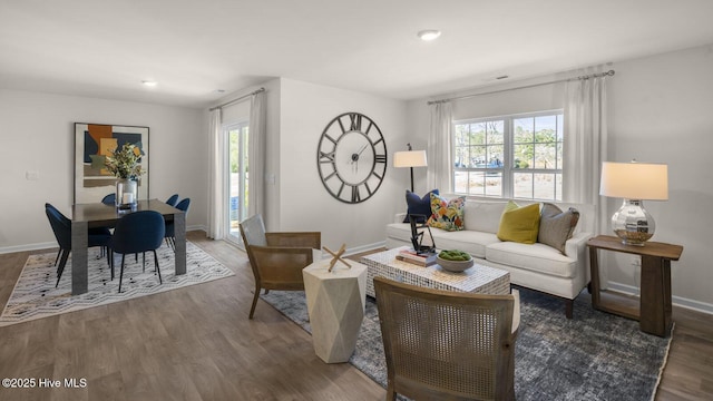 living room featuring a wealth of natural light and dark wood-type flooring