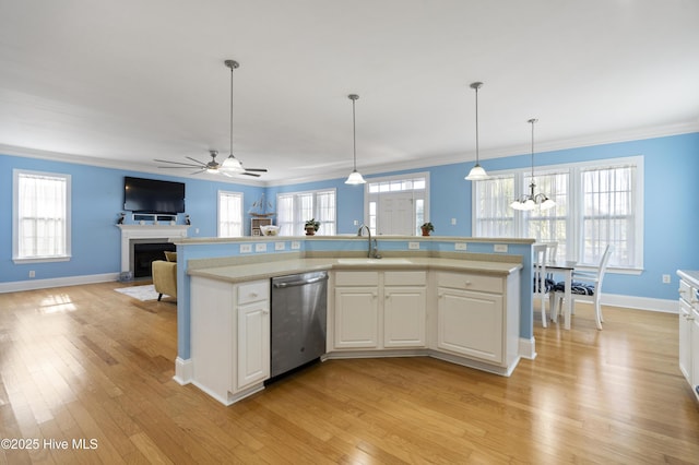 kitchen featuring stainless steel dishwasher, hanging light fixtures, a center island with sink, white cabinetry, and ceiling fan with notable chandelier