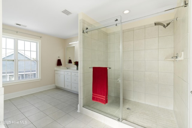 bathroom featuring tile patterned flooring, walk in shower, and vanity