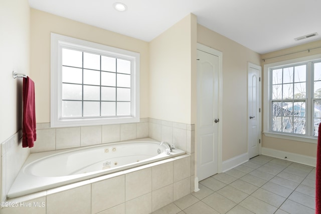 bathroom featuring tiled tub, tile patterned floors, and plenty of natural light