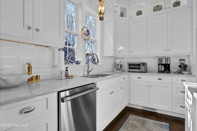 kitchen featuring light stone countertops, dishwasher, white cabinetry, decorative backsplash, and sink