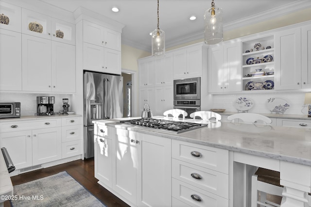 kitchen with stainless steel appliances, pendant lighting, white cabinetry, and light stone countertops