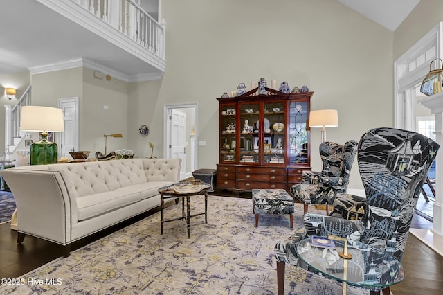 living room with a high ceiling, ornamental molding, and hardwood / wood-style flooring