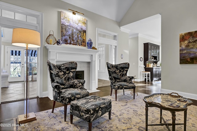 living room with dark wood-type flooring, ornamental molding, and lofted ceiling