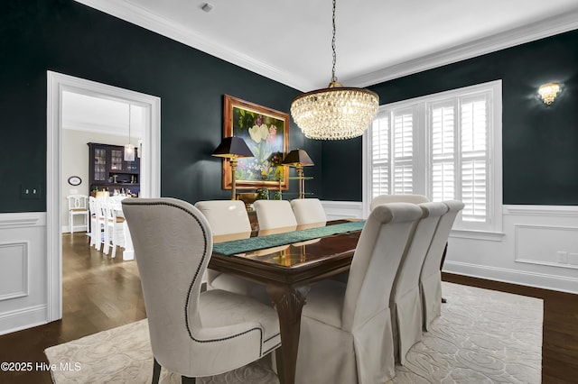 dining area featuring dark hardwood / wood-style flooring, an inviting chandelier, and ornamental molding