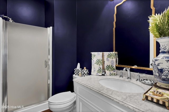 bathroom with toilet, vanity, and an enclosed shower