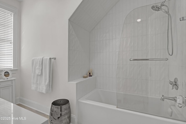 bathroom with tiled shower / bath combo and vanity