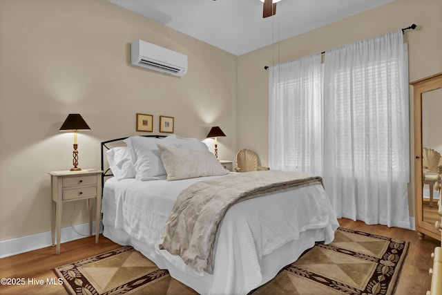 bedroom featuring ceiling fan, hardwood / wood-style floors, and a wall mounted air conditioner