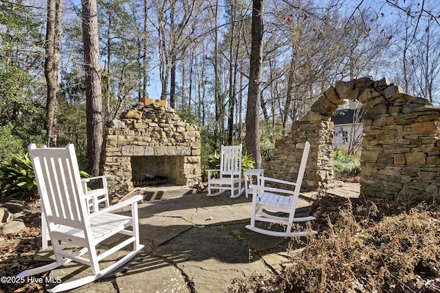 view of yard with an outdoor stone fireplace and a patio