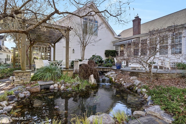 view of yard with a pergola and a garden pond