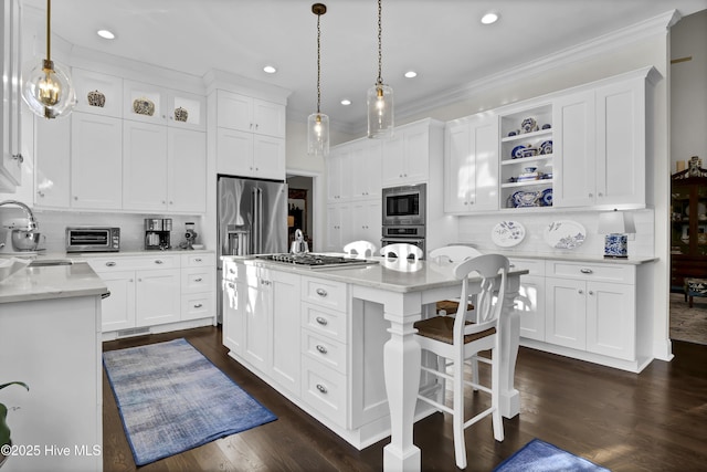 kitchen with decorative light fixtures, appliances with stainless steel finishes, and white cabinetry