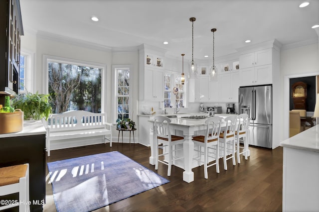 dining room featuring dark wood-type flooring, ornamental molding, and sink