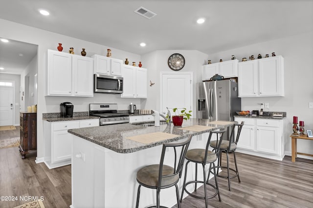 kitchen with appliances with stainless steel finishes, an island with sink, white cabinetry, and sink