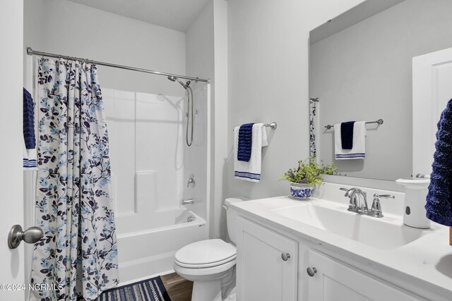 full bathroom featuring shower / bathtub combination with curtain, hardwood / wood-style flooring, vanity, and toilet