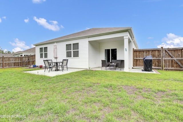 rear view of property with a lawn and a patio area