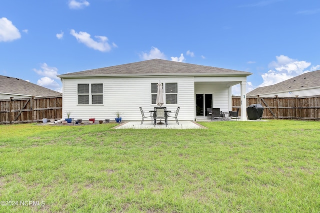 rear view of house featuring a lawn and a patio area