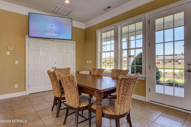 dining space featuring ornamental molding and light tile patterned floors