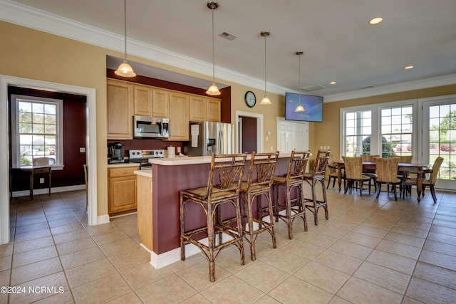 kitchen featuring a center island, a breakfast bar, light tile patterned floors, appliances with stainless steel finishes, and light brown cabinets