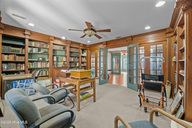 office featuring built in features, wooden walls, ceiling fan, light carpet, and french doors