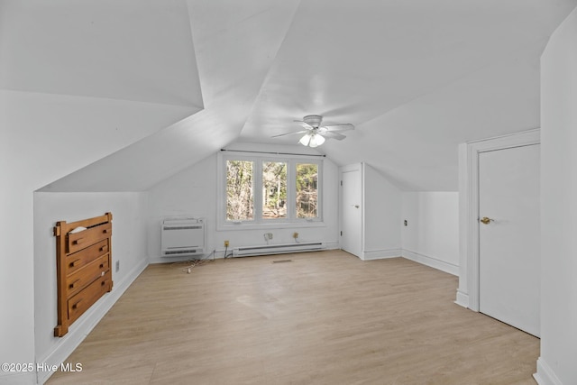 bonus room with a baseboard radiator, vaulted ceiling, heating unit, and light hardwood / wood-style floors