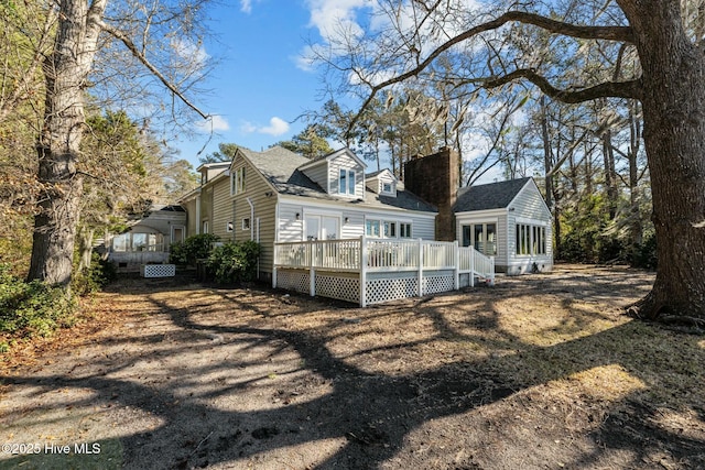 rear view of house featuring a wooden deck