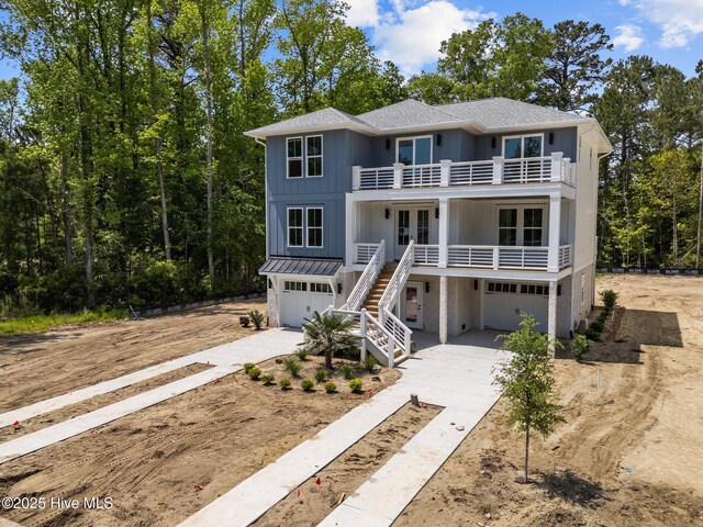 rear view of house with stairway, a shingled roof, a balcony, board and batten siding, and french doors