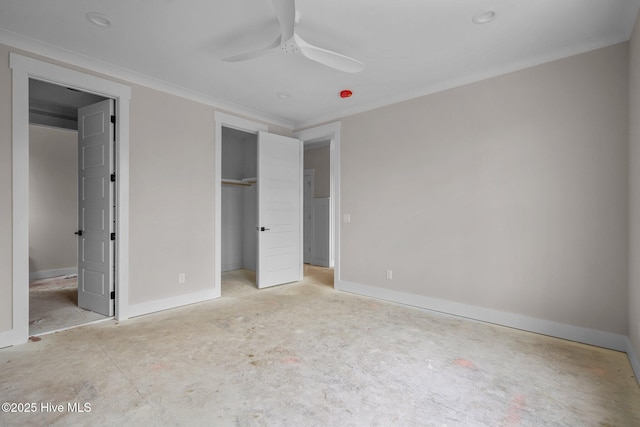 unfurnished bedroom with a spacious closet, a closet, a ceiling fan, and baseboards