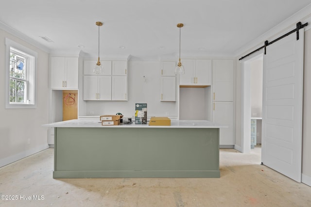 kitchen with a kitchen island with sink, hanging light fixtures, and white cabinets